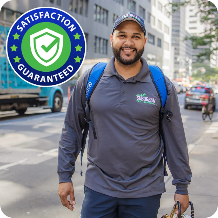 Suburban Pest technician smiling outside near office building