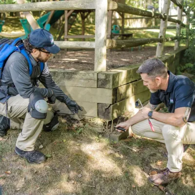technicians outside looking at structure of home 