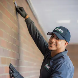 technician outside working on brick wall