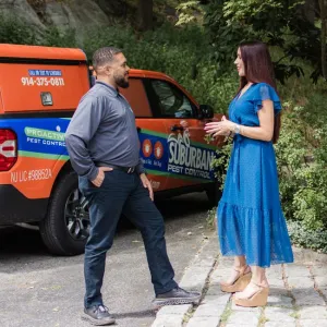 technician speaking with customer outside of home