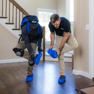 technicians putting foot coverings on in house