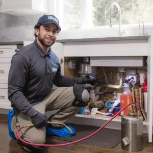 technician working under kitchen sink