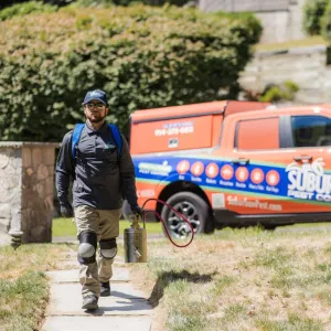 technician walking company vehicle in the background