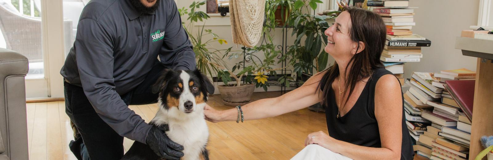 a suburban pest control tech with a dog and home owner