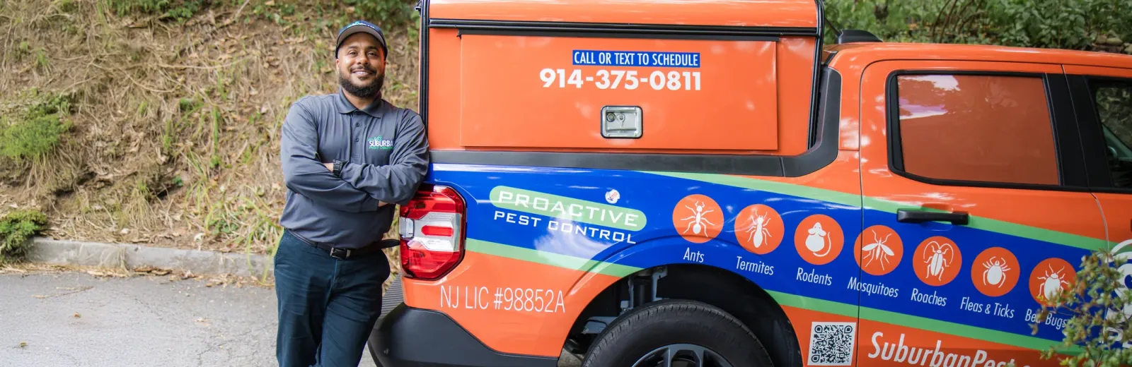 technician leaning against the back of suburban pest company vehicle