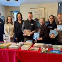The Suburban Pest Control team with a table of books