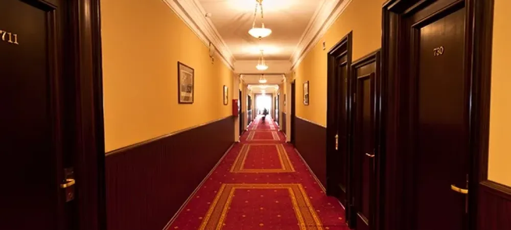 hotel hallway with a red carpet and brown doors