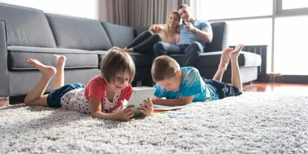 kids laying on the floor with their parents on the couch behind them